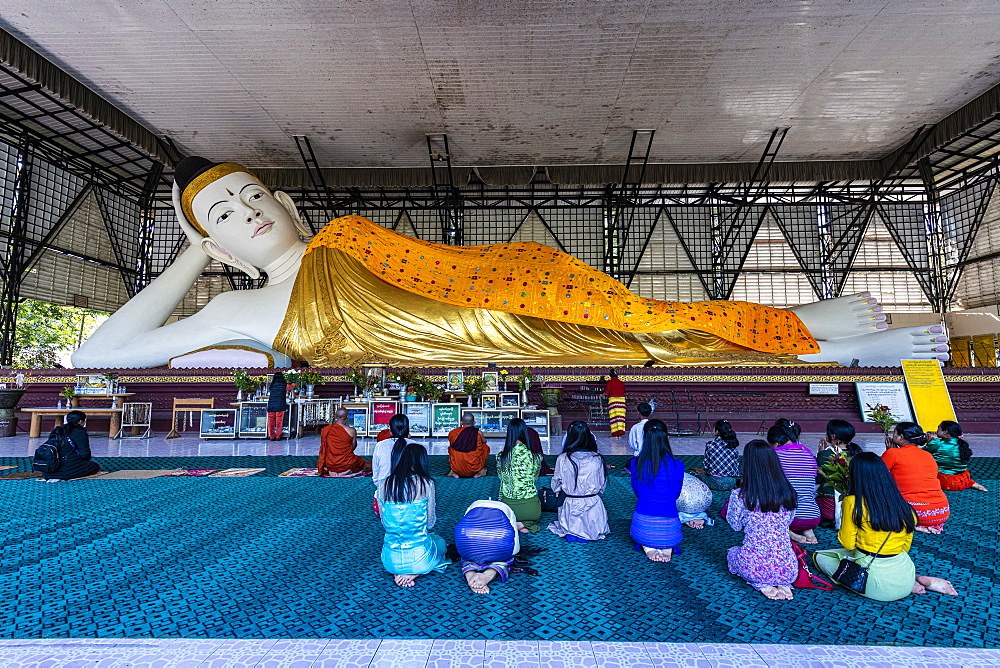 Pilgrims praying before a reclining Buddha, Su Taung Pyi pagoda, Myitkyina, Kachin state, Myanmar (Burma), Asia