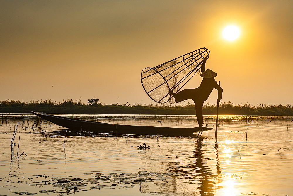 Fisherman at Inle Lake with traditional Intha conical net at sunset, fishing net, leg rowing style, Intha people, Inle Lake, Shan state, Myanmar (Burma), Asia