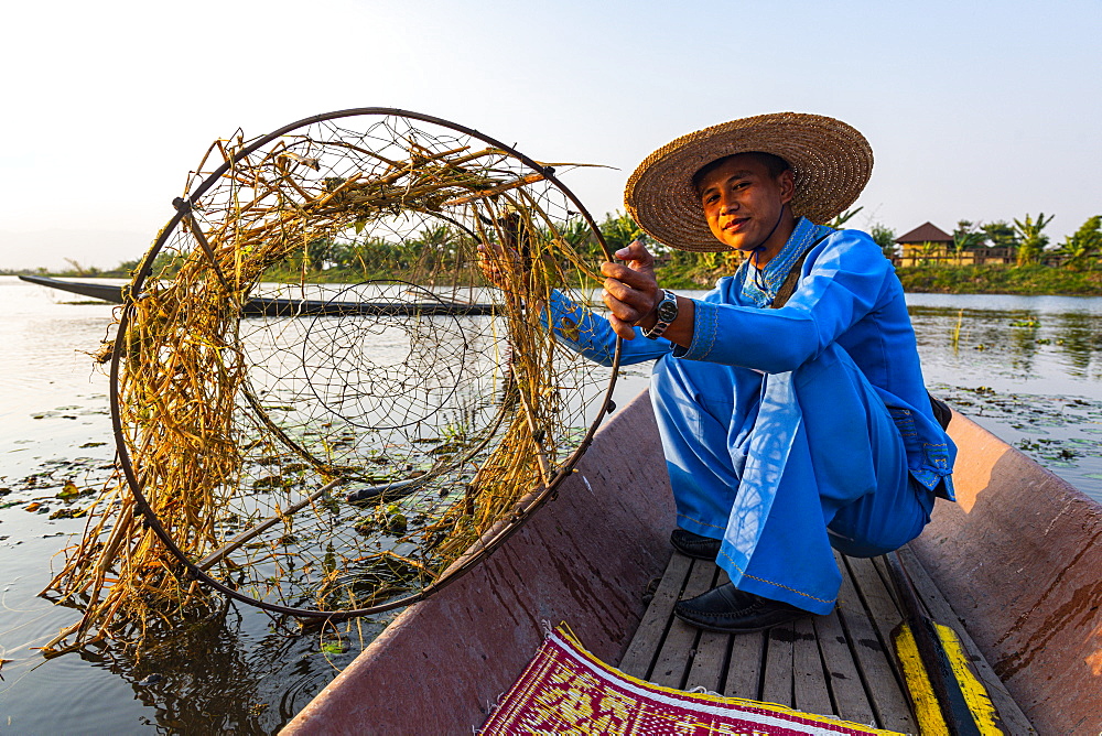 Fisherman at Inle Lake with traditional Intha conical net at sunset, fishing net, leg rowing style, Intha people, Inle Lake, Shan state, Myanmar (Burma), Asia