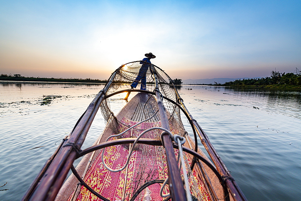 Fisherman at Inle Lake with traditional Intha conical net at sunset, fishing net, leg rowing style, Intha people, Inle Lake, Shan state, Myanmar (Burma), Asia