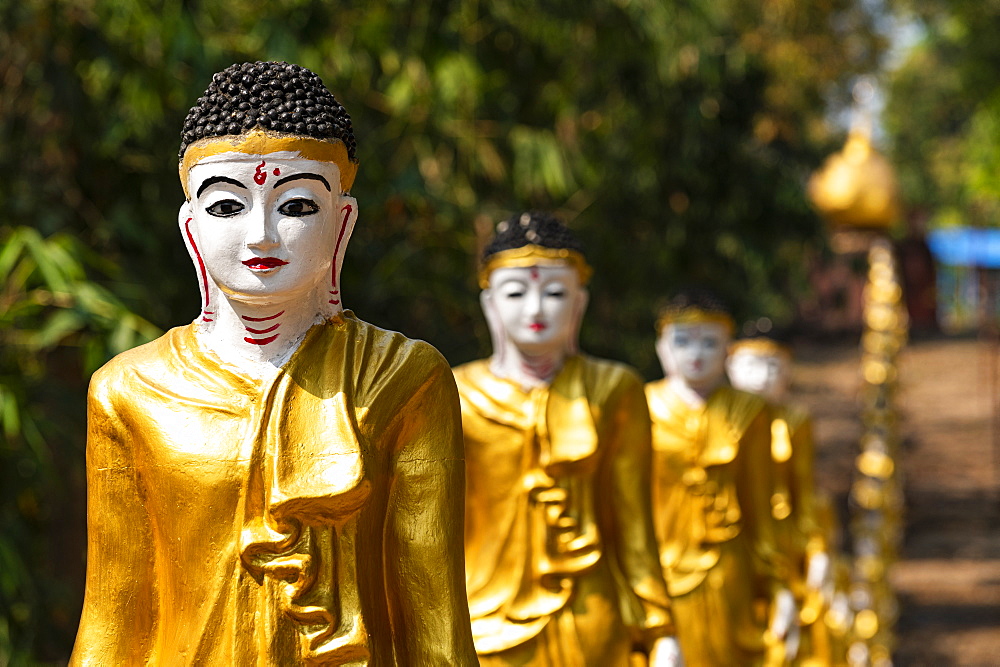 Long line of golden Buddhas lining up to Shwemawdaw Paya, Kyaing Ywar near Ye, Mon state, Myanmar (Burma), Asia