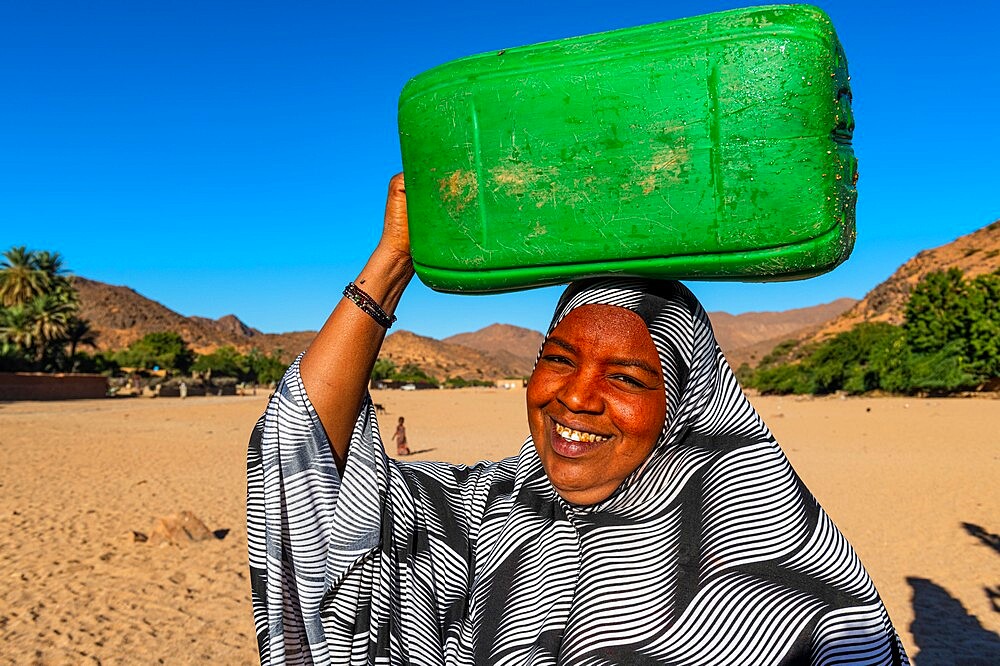 Woman carrying a water container on her head, Oasis of Timia, Air Mountains, Niger, Africa