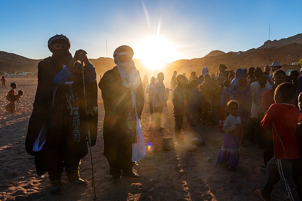 Backlight of a crowd of children and Tuareg men, Oasis of Timia, Air Mountains, Niger, Africa