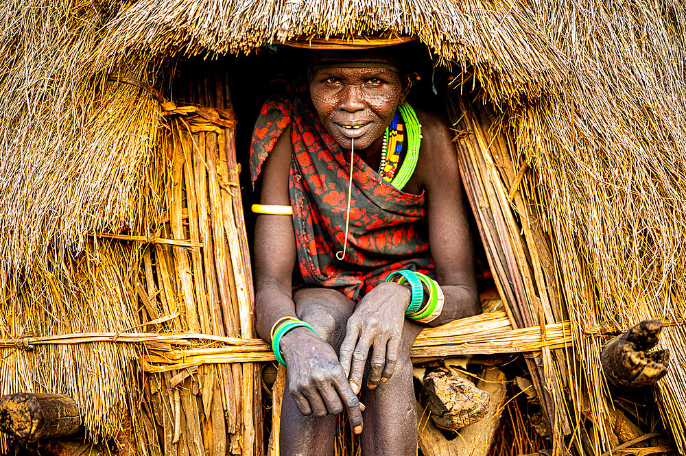 Scar face as a mark of beauty on woman from the Jiye tribe sitting in her hut, Eastern Equatoria State, South Sudan, Africa