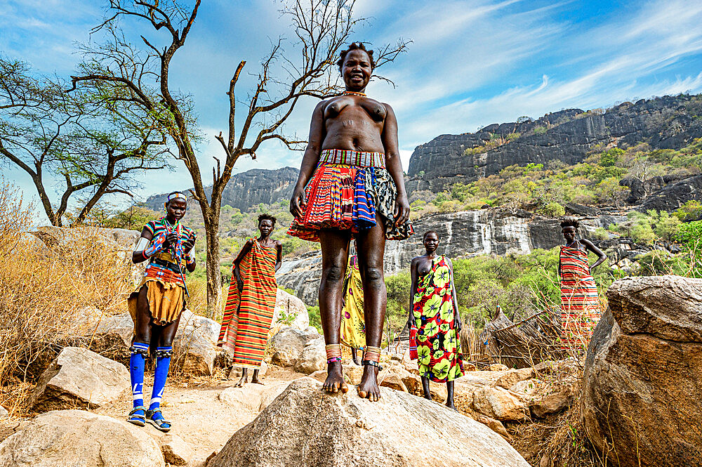 Traditional dressed young girls from the Laarim tribe standing on a rock, Boya Hills, Eastern Equatoria, South Sudan, Africa