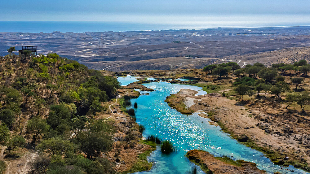 Aerial of a turquoise river in Wadi Darbat, Salalah, Oman, Middle East