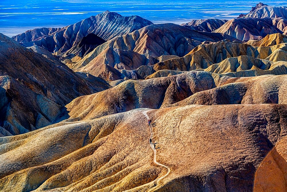 Hikers in the Colourful sandstone formations, Zabriskie Point Death valley, California, USA