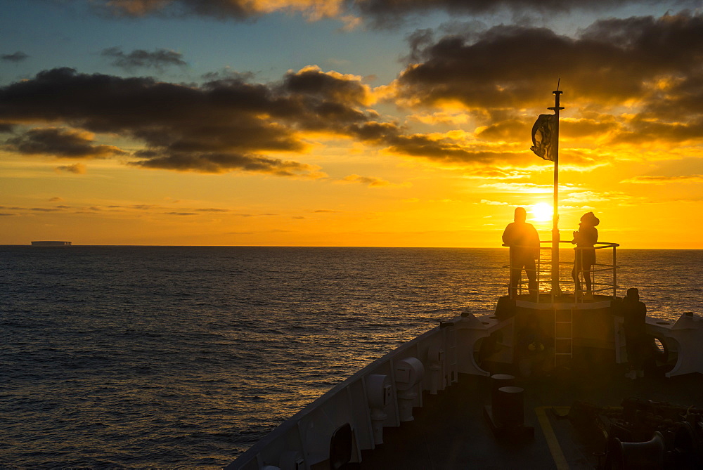 Tourists standing on the bow of a cruise ship watching the sunset, South Orkney Islands, Antarctica, Polar Regions