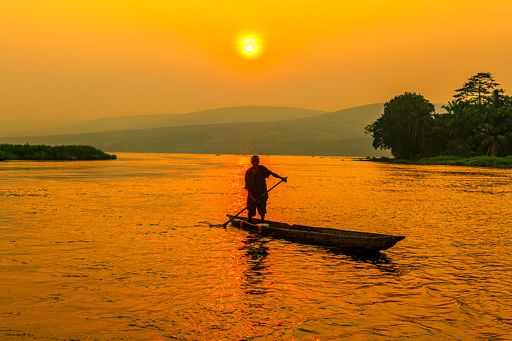 Man on his dugout canoe at sunset on the Congo River, Democratic Republic of the Congo, Africa