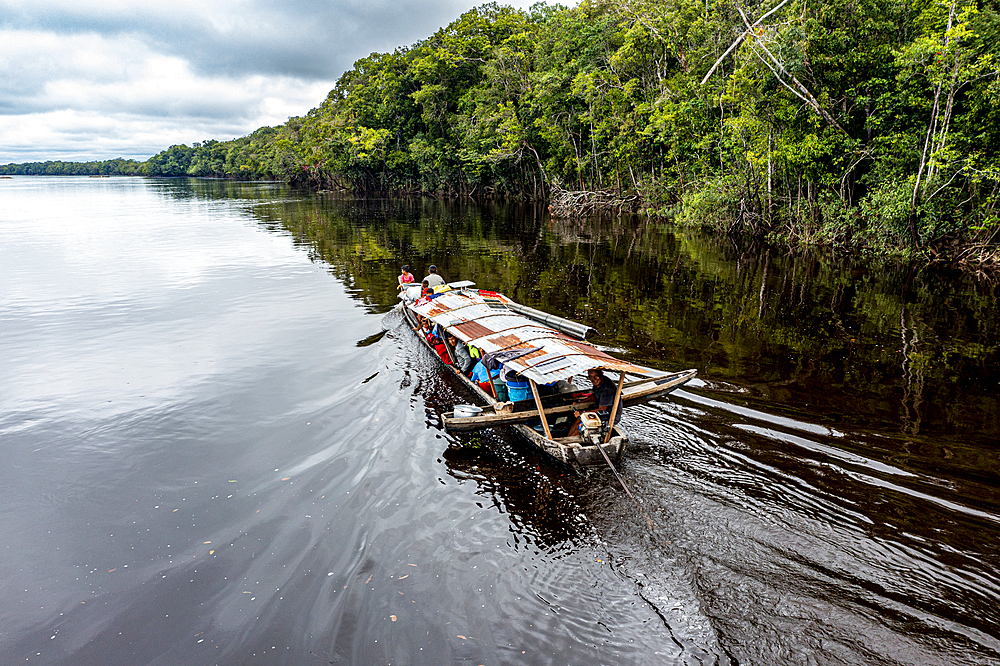 Illegal miners on their boat on the black Pasimoni River, in the deep south of Venezuela, South America