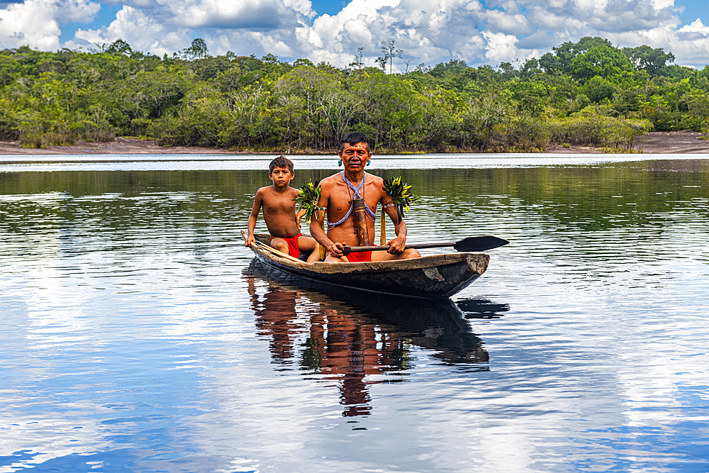 Father and son from the Yanomami tribe in a canoe, southern Venezuela, South America