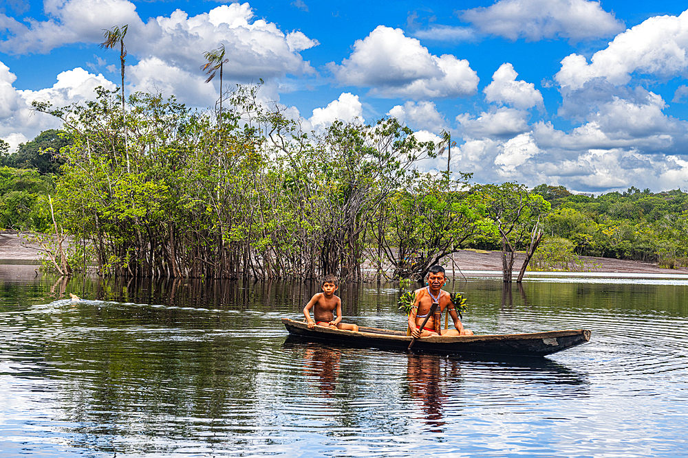 Father and son from the Yanomami tribe in a canoe, southern Venezuela, South America