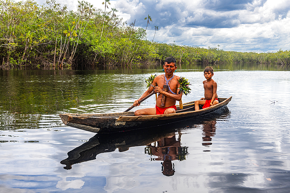 Father and son from the Yanomami tribe in a canoe, southern Venezuela, South America