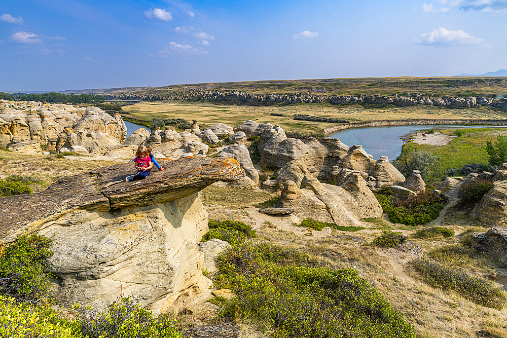 Children playing on a Hoodoo along the Milk River, Writing-on-Stone Provincial Park, UNESCO World Heritage Site, Alberta, Canada, North America