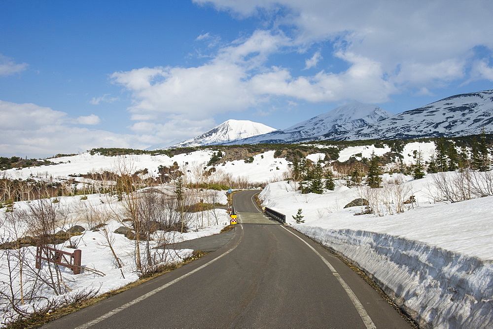 Road leading through the snow capped mountains of the Daisetsuzan National Park, UNESCO World Heritage Site, Hokkaido, Japan, Asia