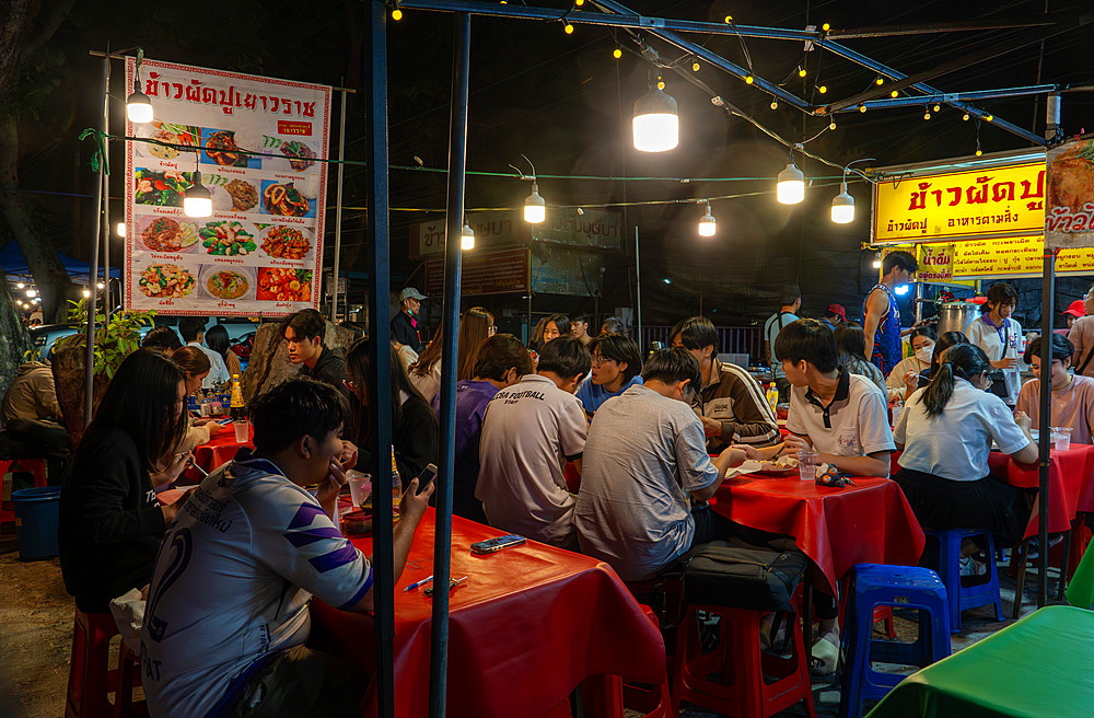 Students from Chiang Mai University eating in street food market, Chiang Mai, Thailand