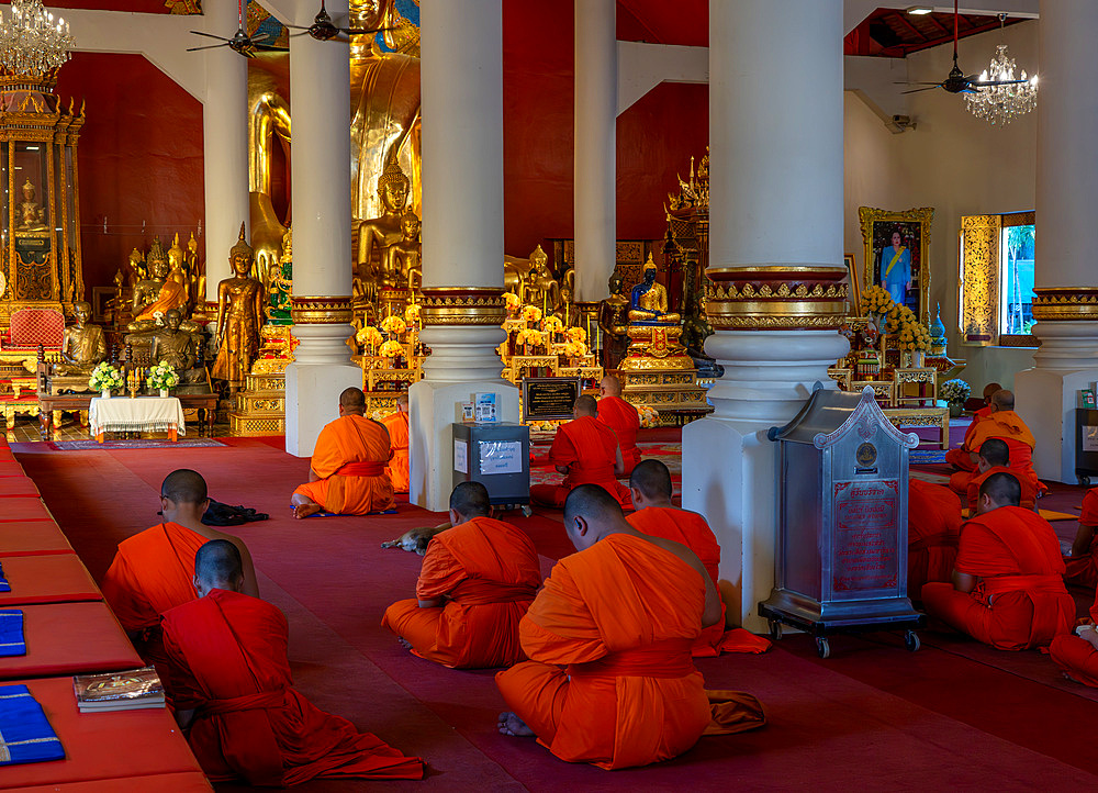 Monks praying and chanting at a Buddhist temple in Chiang Mai, Thailand