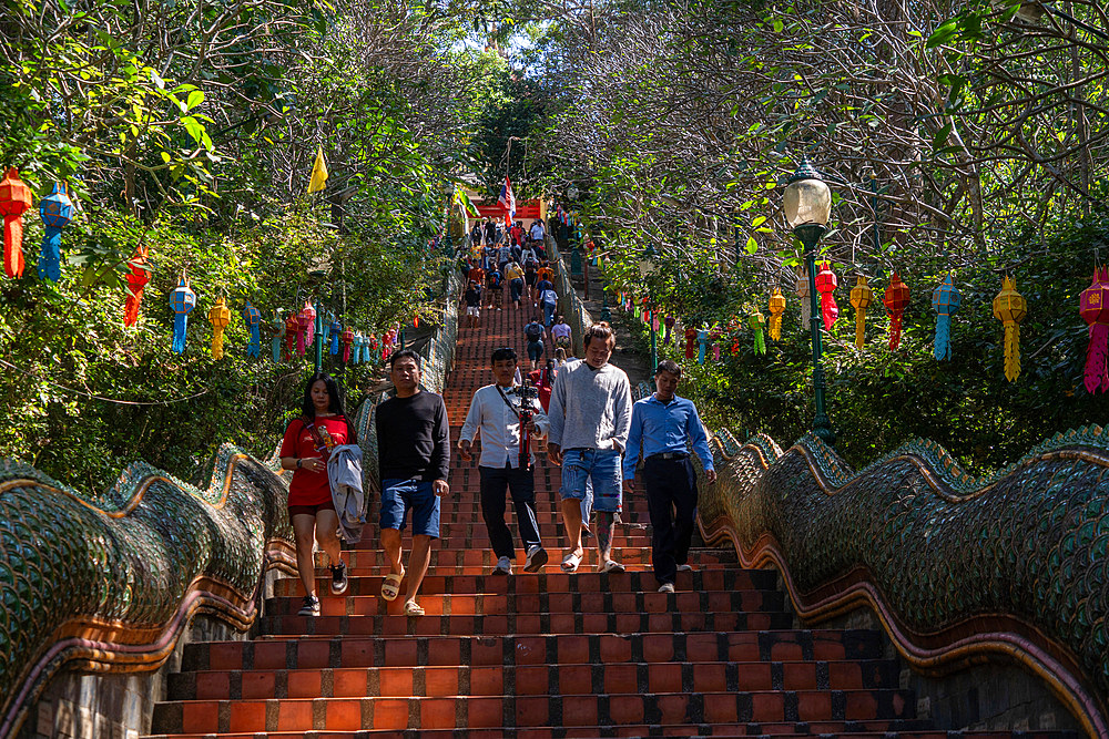 View and visitors and tourists praying at the Wat Suthep historical Buddhist temple in the forest above Chiang Mai, Thailand