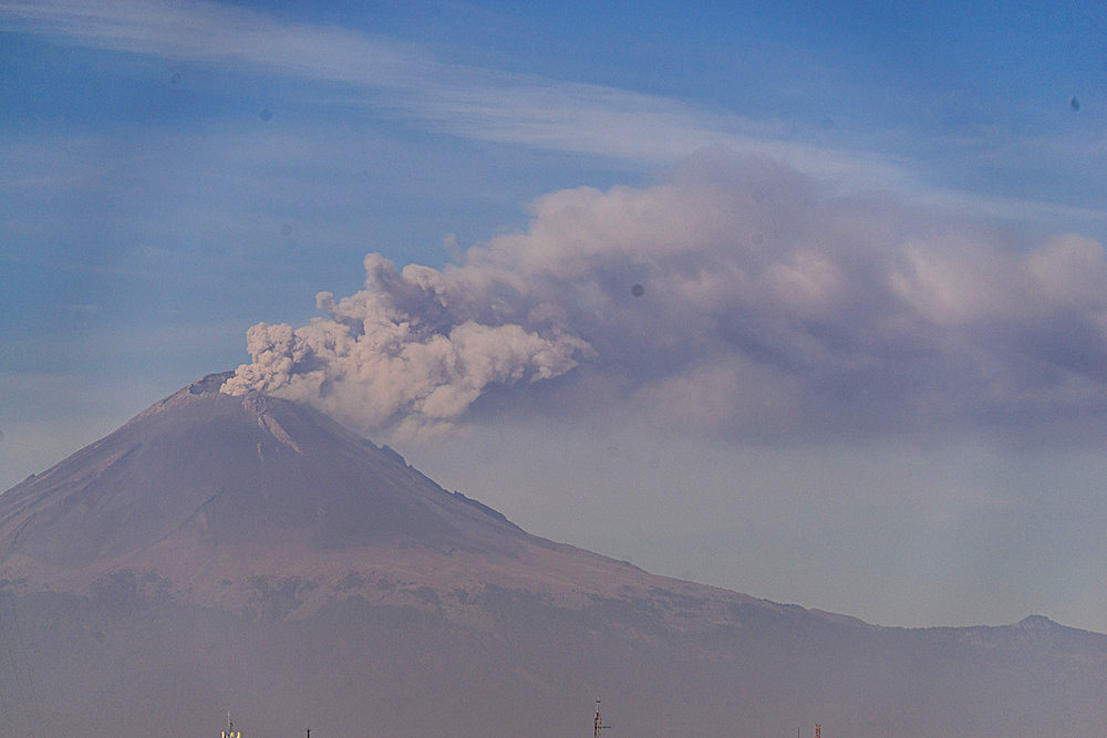 Views of the active Popocateptl volcano, with a plume of smoke from historical old town in Puebla,Mexico