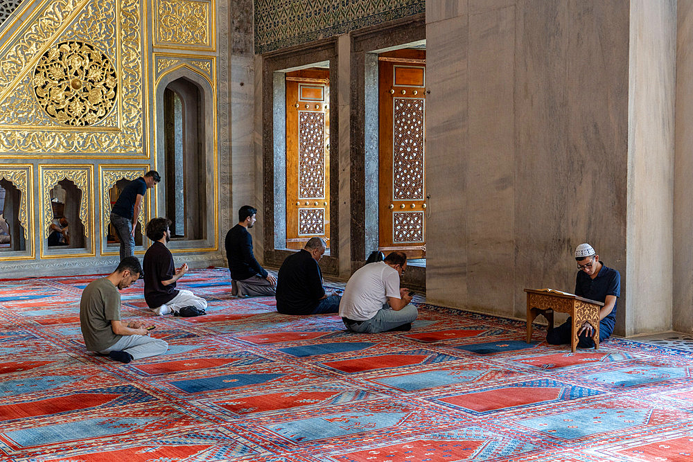 Visitors praying at the Blue Mosque in Istanbul, Turkey, Türkiye