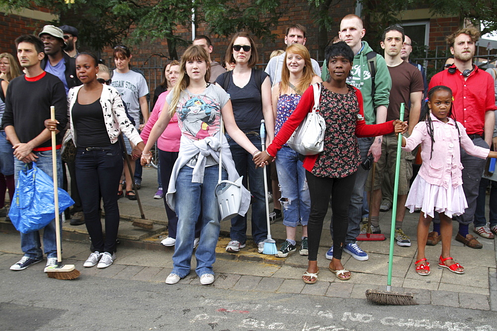 Local community get together to clear damage caused by rioters in Hackney, London, UK ;