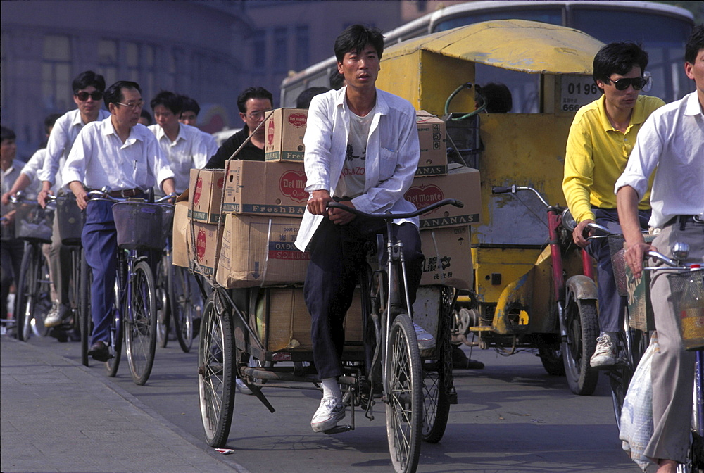 Bicycles, china. Shanghai. Cyclist at a traffic light during rush hour