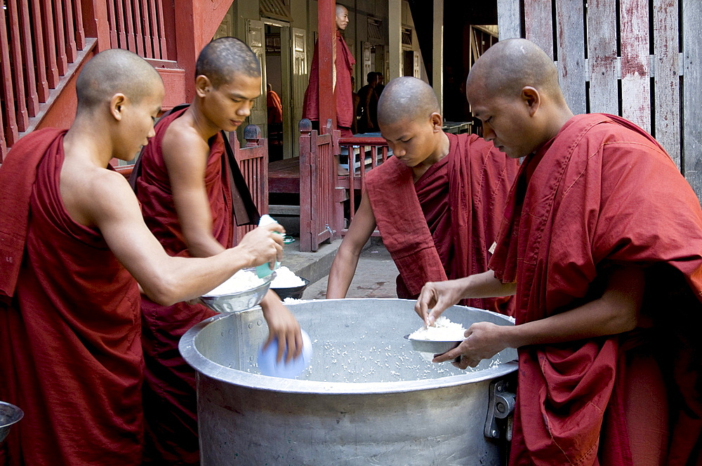 Myanmar (burma) monks helping themselves to rice from a big pot at a monastery in katha, upper irrawady, where george orwells burmese days was set