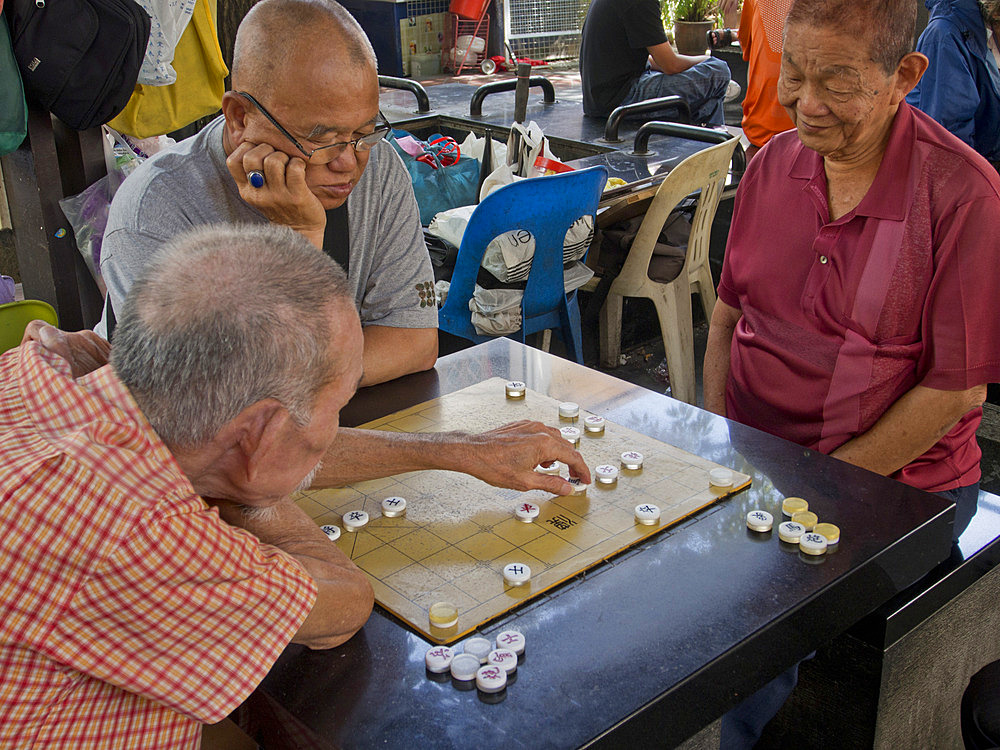 Senior Chinese men playing board game in Chinatown, Singapore, Southeast Asia, Asia