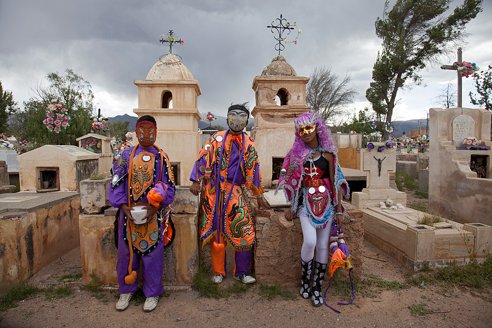 Revellers in costumes and masks at a cemetery in Humahuaca during carnival in Jujuy province in the Andes region of Argentina