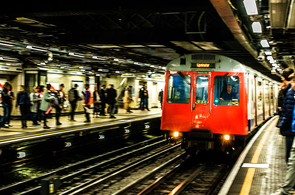 Tube pulling in to a busy underground station, London, England, United Kingdom, Europe