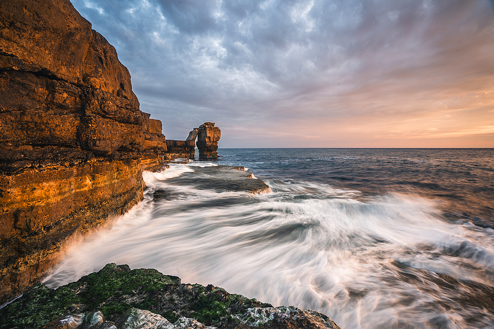 Pulpit Rock at sunset with waves at Portland Bill Lighthouse, Portland, Dorset, UK