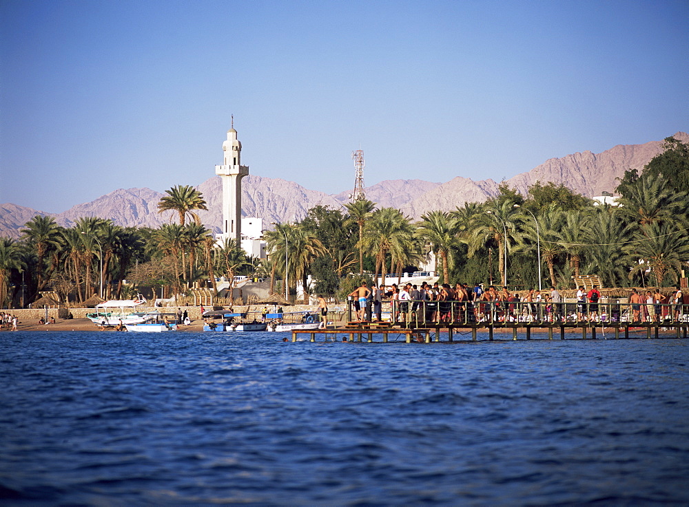 Youths swimming from jetty, town beach, Aqaba, Jordan, Middle East