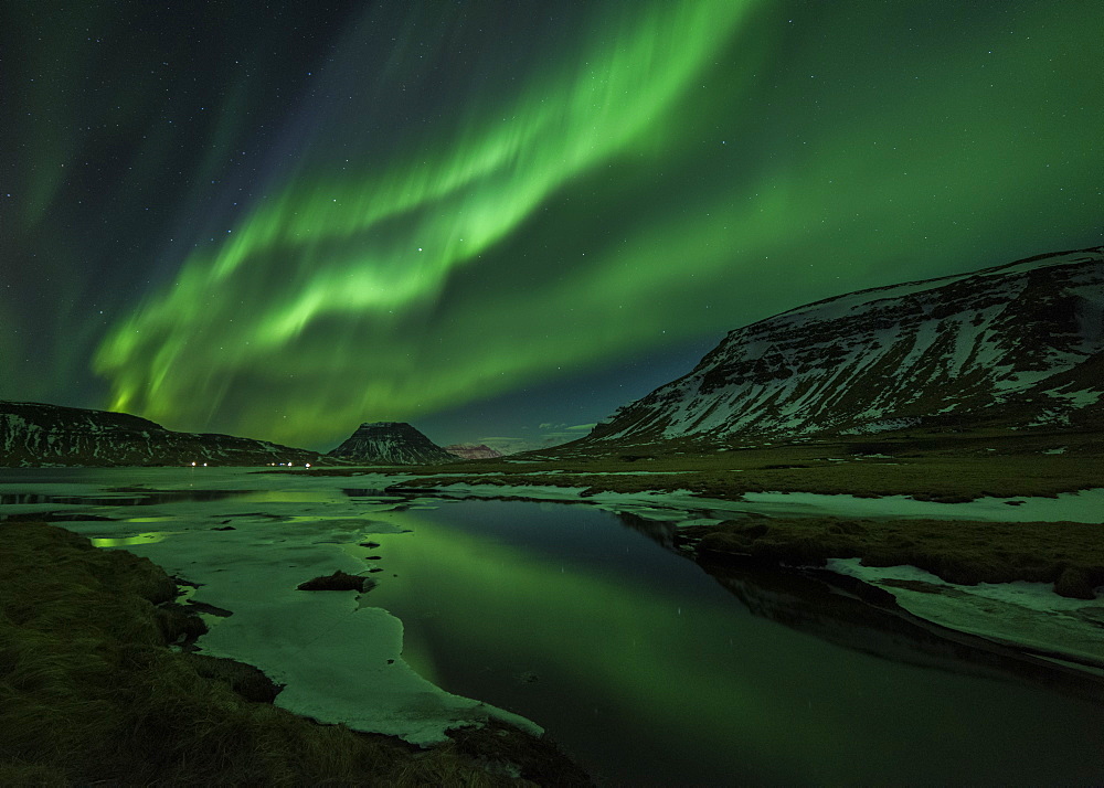 Aurora borealis (Northern Lights) reflected in partially frozen lake, North Snaefellsnes, Iceland, Polar Regions