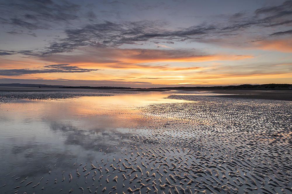 Sunset reflections on sandy beach at sunset, Camber Sands, East Sussex, England, United Kingdom, Europe