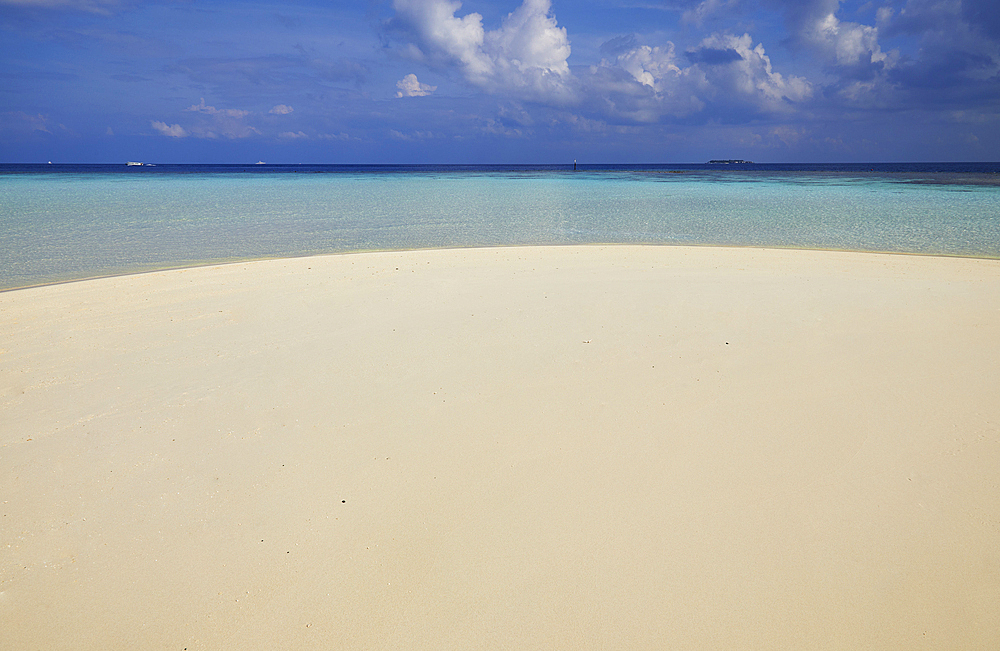 Pristine shallow waters lap against the white coral sand of a tropical beach; Havodda Island, in the far south of the Maldives, Gaafu Dhaalu atoll, Indian Ocean.