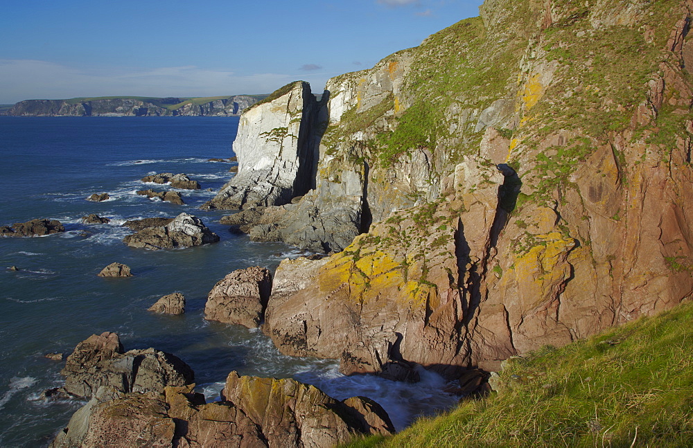 A rocky shoreline in calm summer weather, on Burgh Island, near Bigbury-on-Sea, the south coast of Devon, England, United Kingdom, Europe