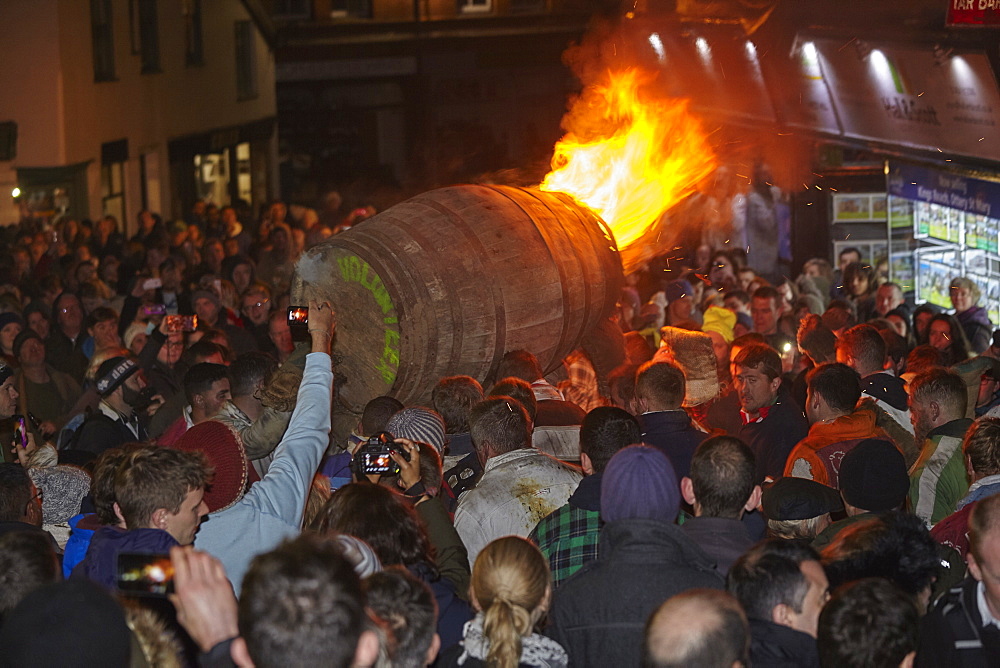 A blazing tar barrel passes through crowded streets during the annual Ottery Tar Barrel Festival, held in early November, Ottery St. Mary, Devon, England, United Kingdom, Europe