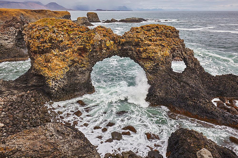 A rock arch among basalt lava cliffs at Arnastapi, on the coast of the Snaefellsnes peninsula, west Iceland, Polar Regions