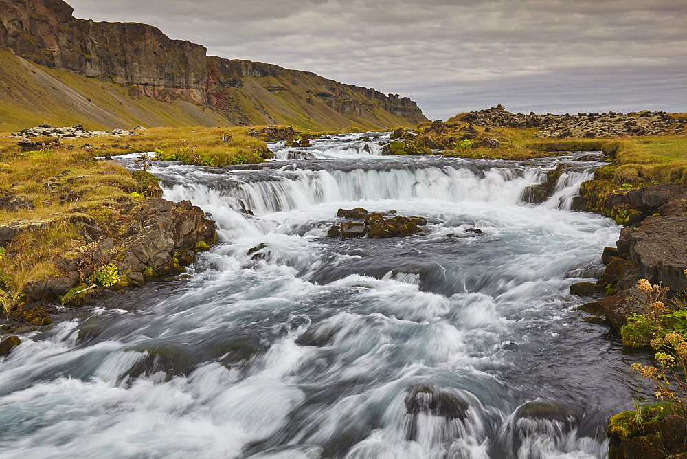 A classic Icelandic landscape, a river flowing along the base of a cliff, The Fossalar River, near Kirkjubaejarklaustur, Iceland, Polar Regions