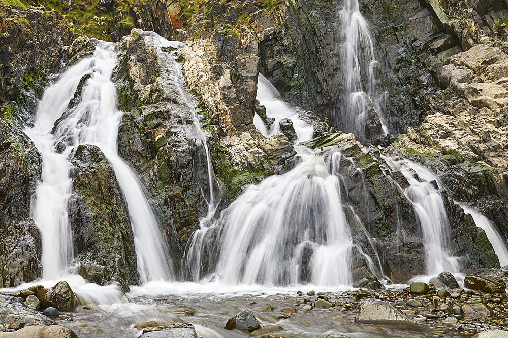 Waterfall pouring down a rocky cliff, with blurred motion, resulting from a slow shutter speed; at Welcombe Mouth, Hartland, north Devon, England, United Kingdom, Europe