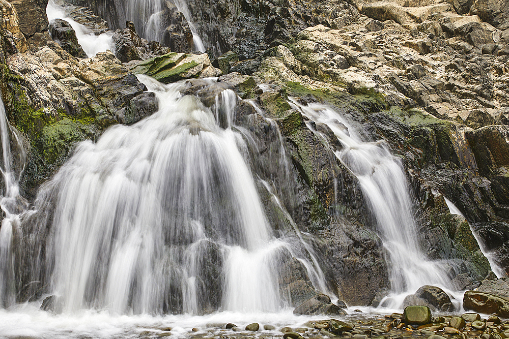 Waterfall pouring down a rocky cliff, with blurred motion, resulting from a slow shutter speed; at Welcombe Mouth, Hartland, north Devon, England, United Kingdom, Europe