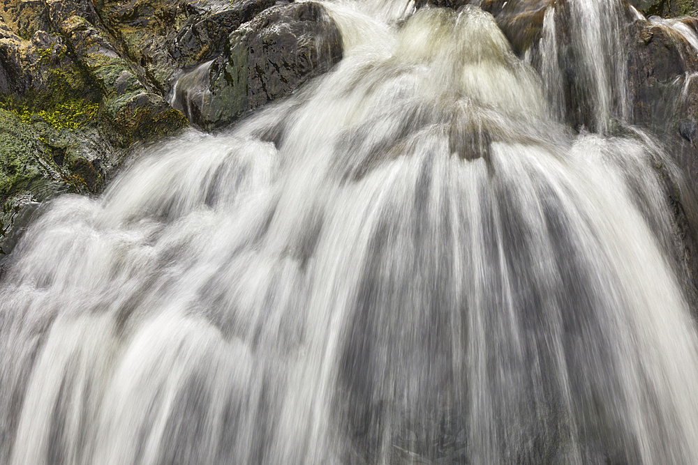 Waterfall pouring down a rocky cliff, with blurred motion, resulting from a slow shutter speed; at Welcombe Mouth, Hartland, north Devon, England, United Kingdom, Europe