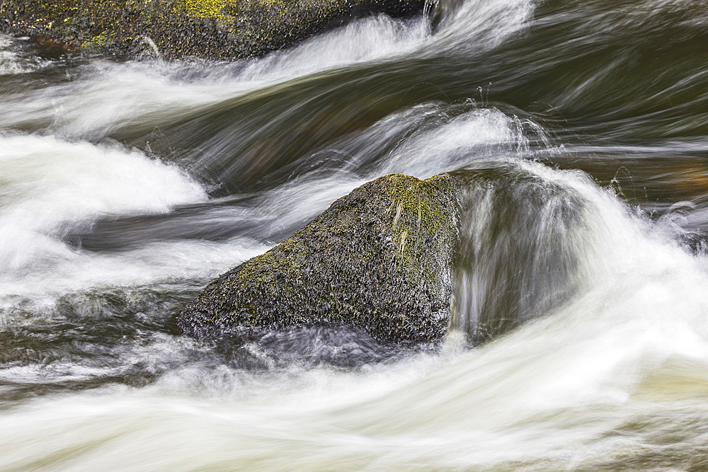 A detail of water flowing around rocks in the River Dart, at Dartmeet, Dartmoor National Park, Devon, England, United Kingdom, Europe