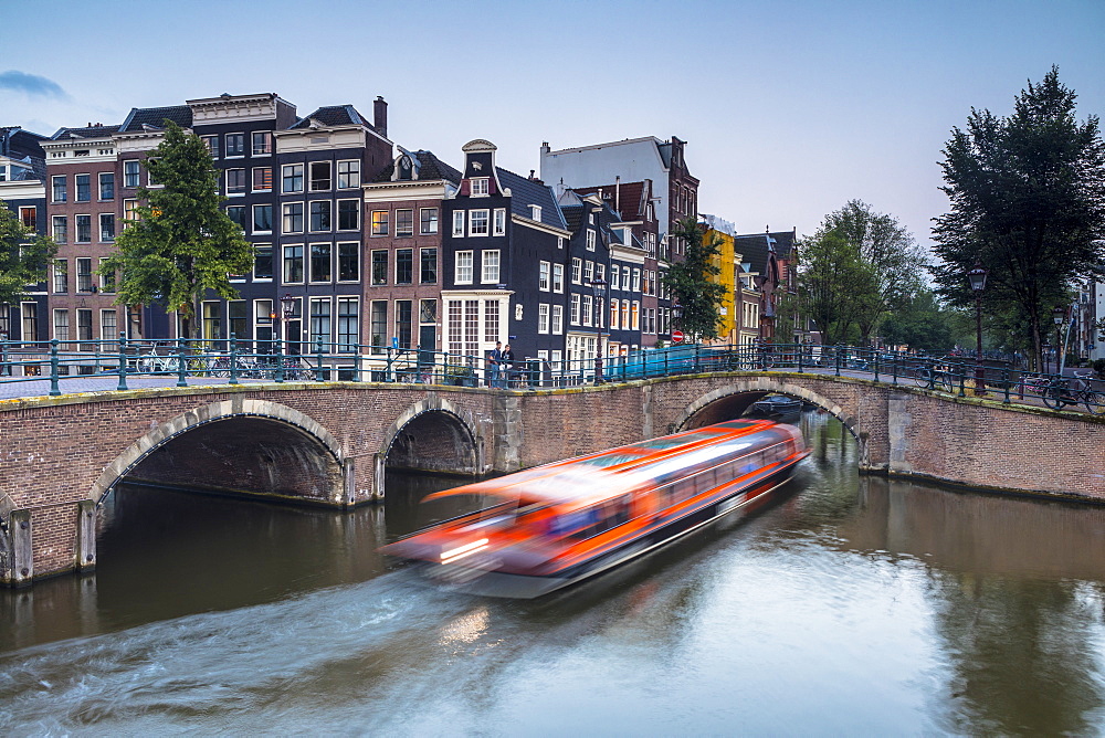 A boat going under a bridge over the Keizersgracht Canal, Amsterdam, Netherlands, Europe