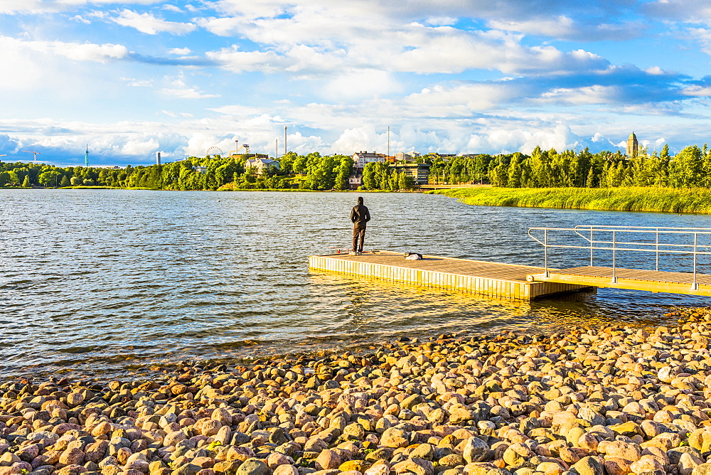 Man fishing on jetty in Toolo Bay, Helsinki, Finland, Europe