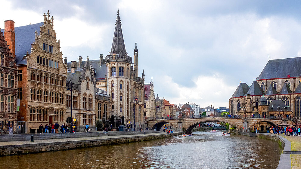 Locals and visitors relax along the Leie canal, famous for its beautiful historic facades, Graslei, Ghent, Belgium, Europe