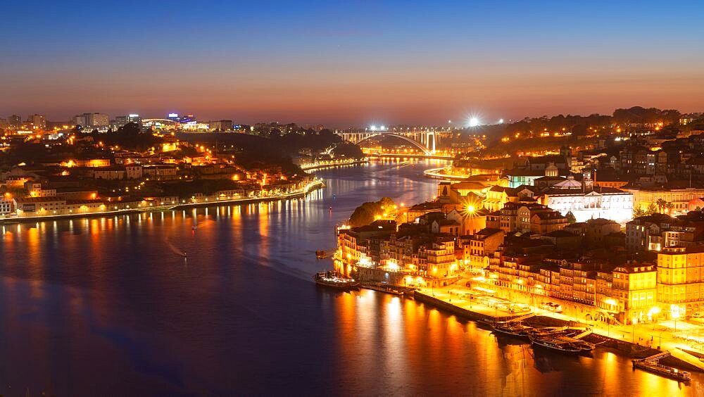 Skyline of the historic city of Porto at night. In the background the bridge Ponte de Arrabida. Portugal, Europe