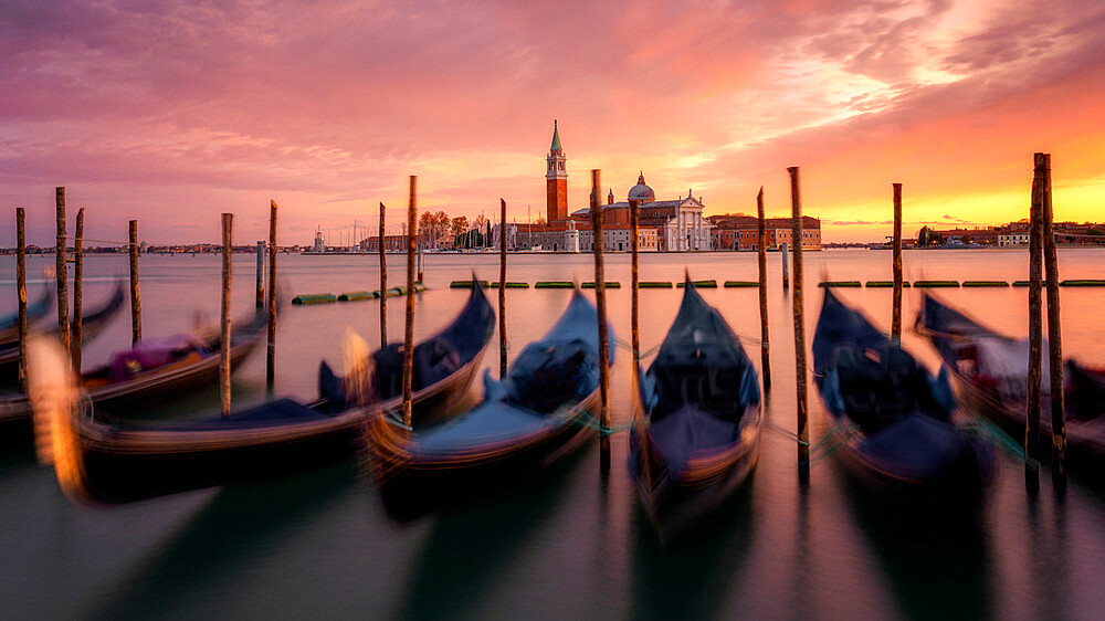 Venetian gondolas at sunset with the church San Giorgio Maggiore in the background, Venice, Veneto, Italy, Europe