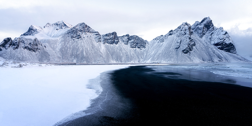 View of the mountains of Vestrahorn from black volcanic sand beach after snowfall, Stokksnes, South Iceland, Iceland, Polar Regions