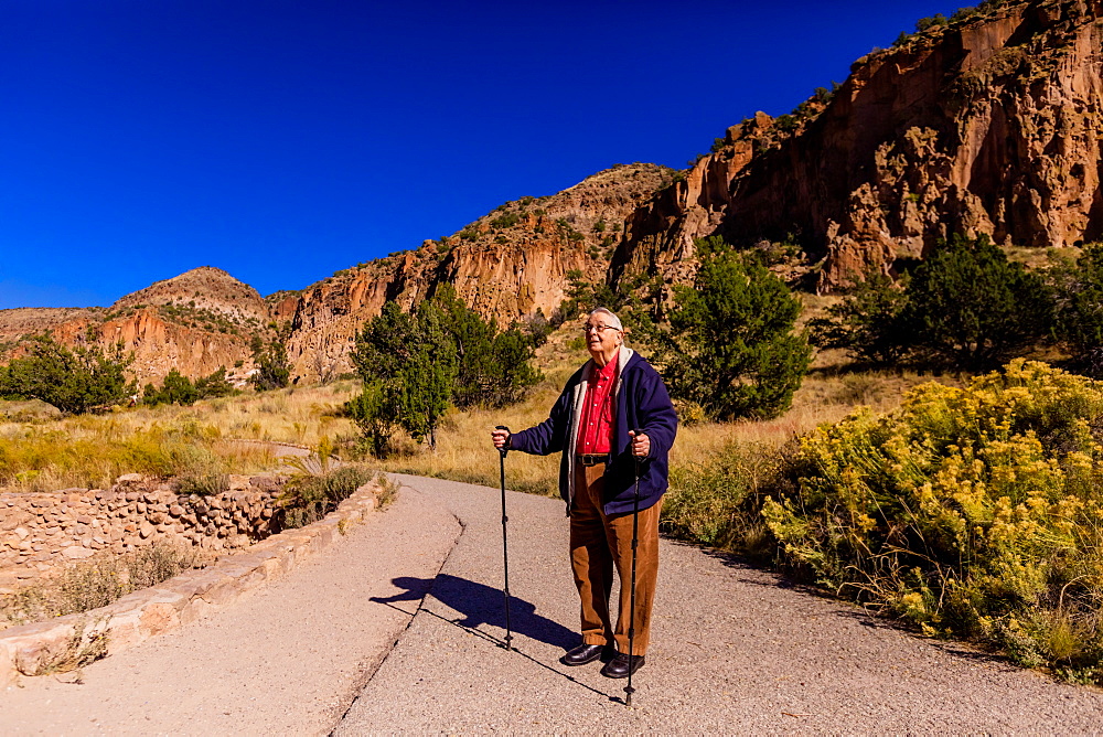 Old man walking through the Pueblo Indian Ruins in Bandelier National Monument, New Mexico, United States of America, North America